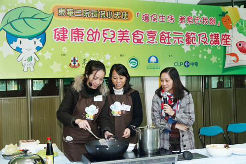 东华三院赛马会天水围综合服务中心的天厨导师(左一及左二)示范菜式「翡翠紫凝卷」。