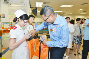 東華三院主席施榮恆先生（右一）巡視廣華醫院門診部賣旗攤位，並感謝協助賣旗的醫護及行政人員。