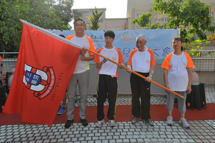 東華三院主席施榮恆先生(左一)在誓師大會上授旗予運動員代表區俊華(左二)、謝玉成(右二)及蘇潔萍，為他們打氣。