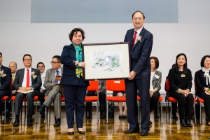 東華三院主席兼名譽校監何超蕸小姐（左）致送紀念品予香港考試及評核局秘書長唐創時博士。