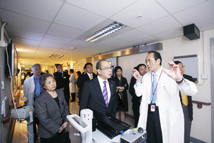 廣華醫院腦外科部門主管郭正光醫生（前排右）向東華三院主席李三元博士（前排中）介紹腦外科治療。