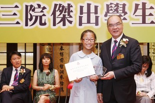 東華三院主席兼名譽校監李三元博士頒發獎項予獲得東華三院小學組傑出學生第一名的東華三院王余家潔紀念小學黎希彤同學。