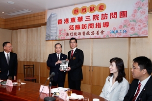 東華三院梁定宇主席（右）致送東華三院一百四十周年歷史書冊《慈與人同》予澳門鏡湖醫院慈善會許世元副主席。