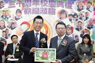 東華三院主席兼名譽校監梁定宇（左）致送紀念品予教育局首席教育主任任衞沛。