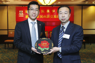國家民政部港澳台辦公室康鵬主任（右）致送紀念品予東華三院，由東華三院梁定宇主席代表接受。