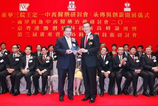 東華三院張佐華主席(右)致送紀念品予主禮嘉賓醫院管理局主席胡定旭GBS太平紳士。