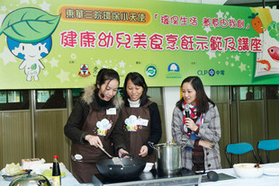 東華三院賽馬會天水圍綜合服務中心的天廚導師(左一及左二)示範菜式「翡翠紫凝卷」。