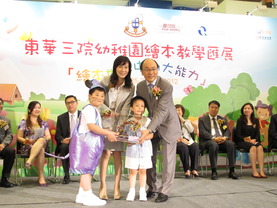 東華三院主席兼名譽校監陳文綺慧（左）由東華三院幼稚園學生陪同致送紀念品予優質教育基金督導委員會主席黃鎮南太平紳士。