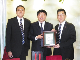 于文明副局長(中)致送紀念品予梁定宇主席(右)及施榮恆副主席。