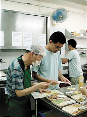 建昌（右）記憶力強，仔細協助餸菜包送遞工作。