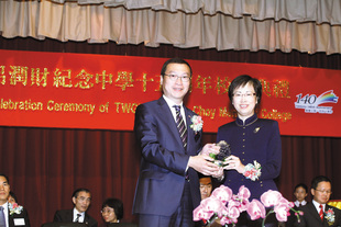 張佐華副主席(左)於東華三院呂潤財紀念中學十五周年校慶典禮上致送紀念品予教育局副秘書長葉曾翠卿太平紳士。