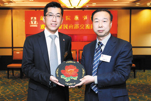 國家民政部港澳台辦公室康鵬主任（右）致送紀念品予東華三院，由梁定宇主席代表接受。