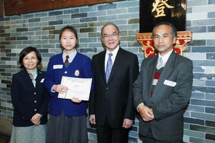東華三院2009/2010年度主席李三元博士(右二)與「東華人•情」創作比賽小學組冠軍東華三院鄧肇堅小學陸文倩同學(左二)合照。