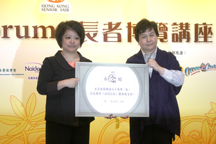 社會服務委員會主任委員何超蕸副主席（右）代表東華接受永念服務有限公司總經理鮑慧玲女士捐贈十個靈灰龕位予參加東華三院「活得自在」計劃的無依長者。