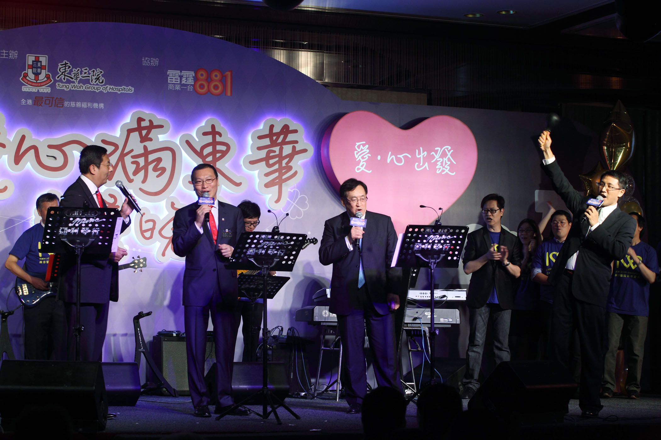 張佐華主席（左二）、施榮恆副主席（左一）、黃永策劃總監（右一），以及由廣華醫院醫護人員組成的BandOne樂隊合作演出，周一嶽局長更即興應邀上台合唱一曲《天才白痴夢》，令場內氣氛推至高峰。