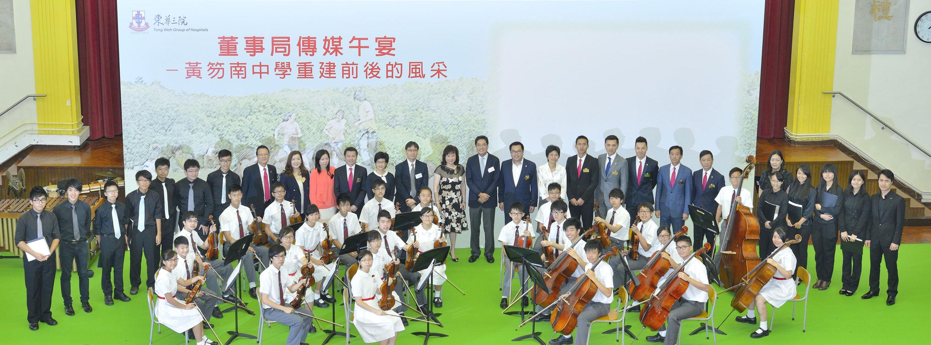 董事局成員聯同政府新聞處官員與東華三院黃笏南中學弦樂團及敲擊樂團成員合照。