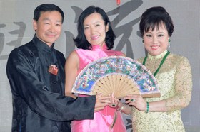 黃業光總理伉儷(左一及中)從陳婉珍主席手中接受於拍賣上所投得的古董象牙扇。
