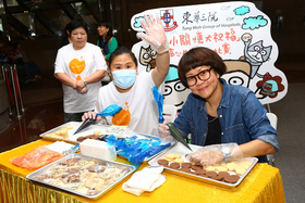 文地（右）與東華三院社會企業iBakery員工敏敏於東華三院「小小關懷大祝福」窩心曲奇設計比賽開展禮上即場示範曲奇繪圖。