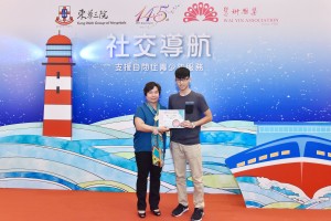 東華三院主席何超蕸小姐（左一）向「相說友情」冠軍得獎者吳子豪同學頒發獎項。