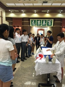 東華三院萬國殯儀館及鑽石山殯儀館駐館的遺體化妝師，向學生們示範為先人穿著壽衣