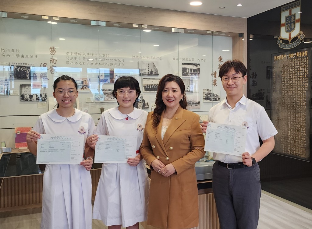 圖一為東華三院主席兼校監鄧明慧女士(右二)祝賀三位考獲DSE佳績的同學─梁縈牽同學(左一)、徐藝瑞同學(左二)及孫啓畯同學(右一)。