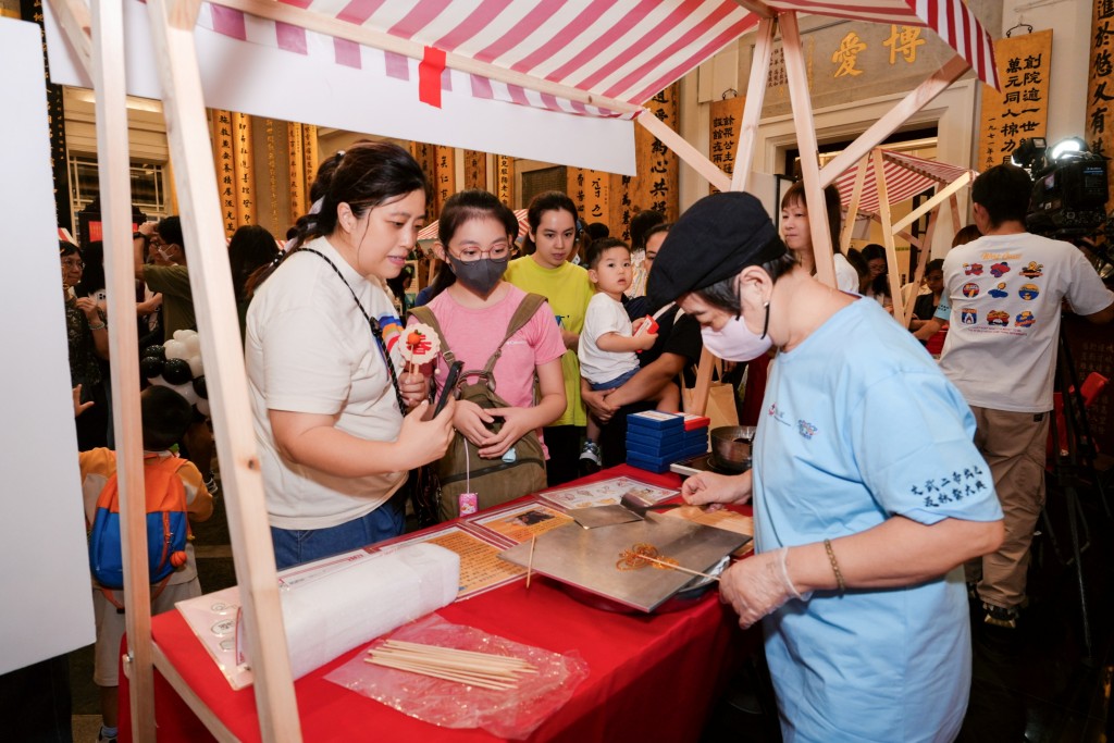 圖九為活動當天下午設有多個中華文化攤位，圖中市民正體驗製作傳統「糖畫」感受非物質文化遺產的樂趣。 