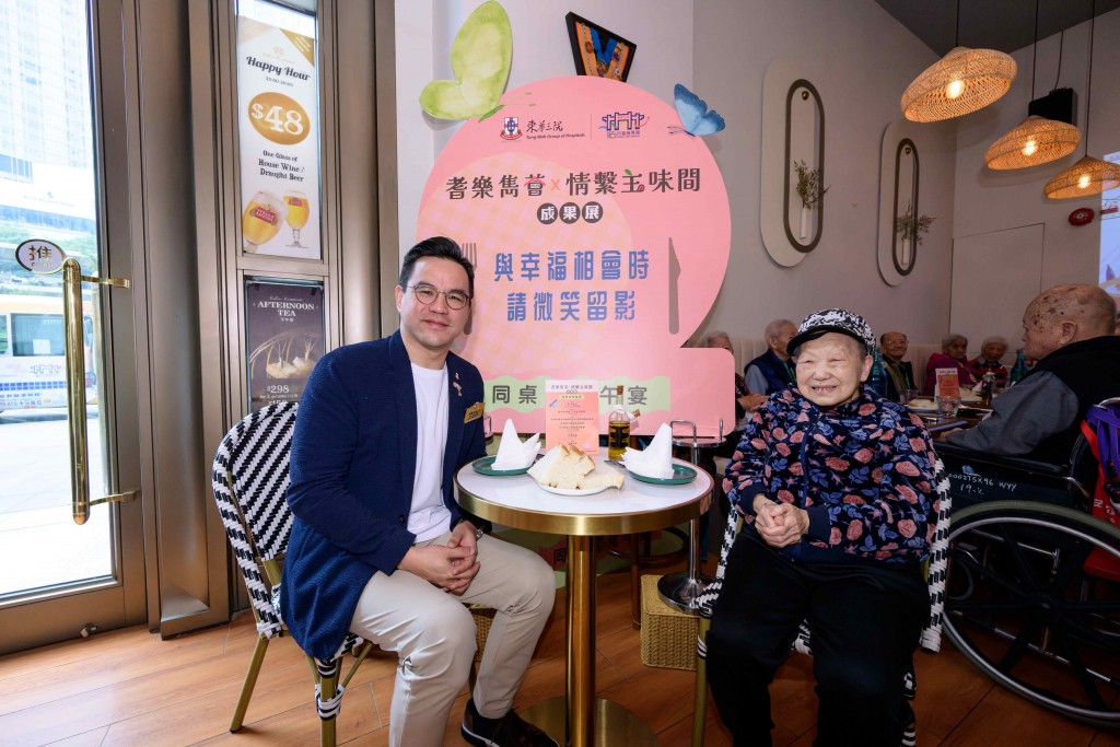 圖四為東華三院副主席李曠怡先生與一眾高級職員及安老院長者一同參與「同桌同食午宴」。李曠怡副主席(左)於午宴時與參加長者合照留念。