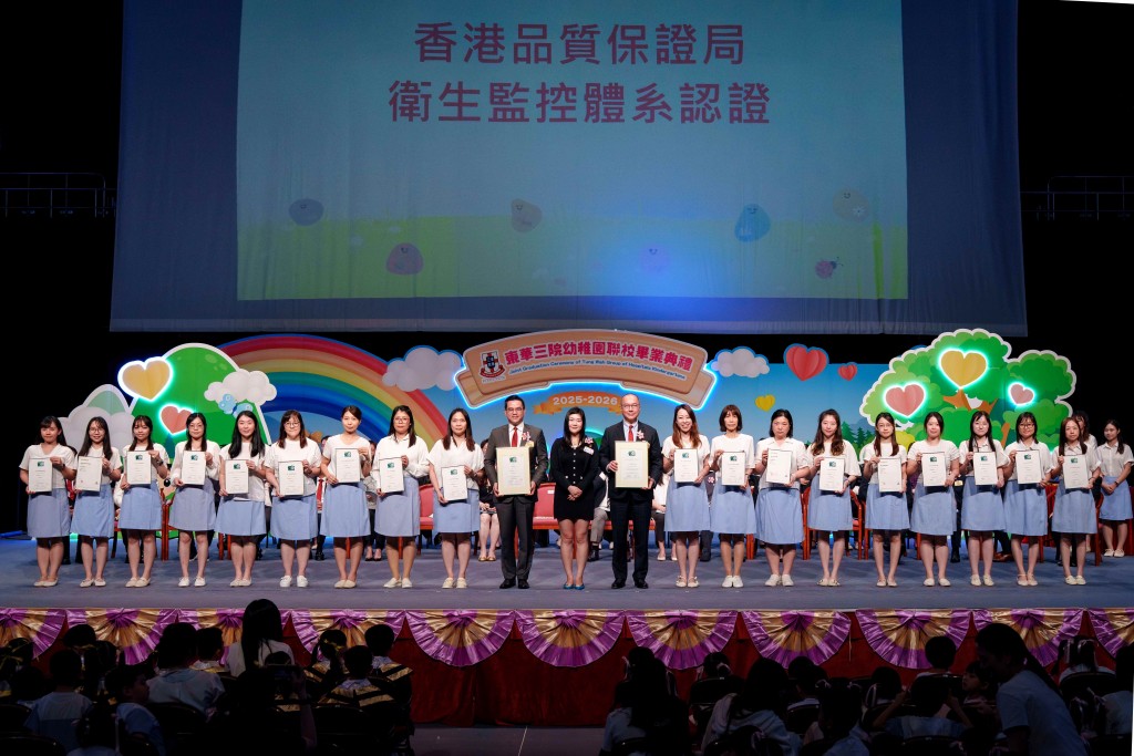 圖五為香港品質保證局業務助理總經理何曉彤女士(中)頒發衞生監控體系認證證書,由本院主席兼校監曾慶業先生(右十)及學務委員會主任委員李曠怡副主席(左十)聯同18所幼稚園教師代表接受。